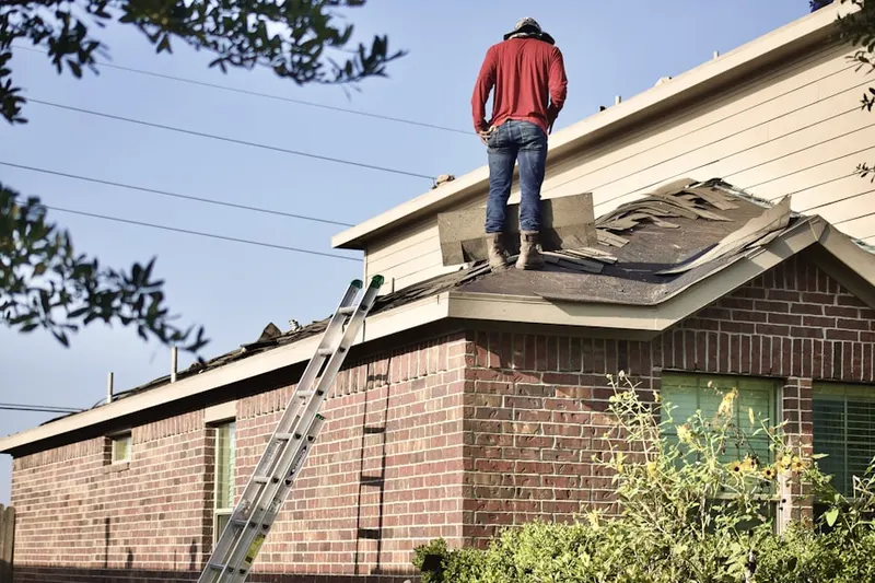 Professional roofer working on a residential roof in Attleboro
